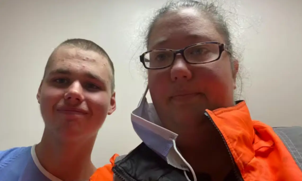 Logan Tozer, left, and his mother pose for a photo at the hospital where he was being assessed on Wednesday. Logan, who has autism, was missing for more than two weeks before police found him in an abandoned building in Havelock, Ont.
