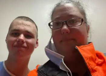 Logan Tozer, left, and his mother pose for a photo at the hospital where he was being assessed on Wednesday. Logan, who has autism, was missing for more than two weeks before police found him in an abandoned building in Havelock, Ont.