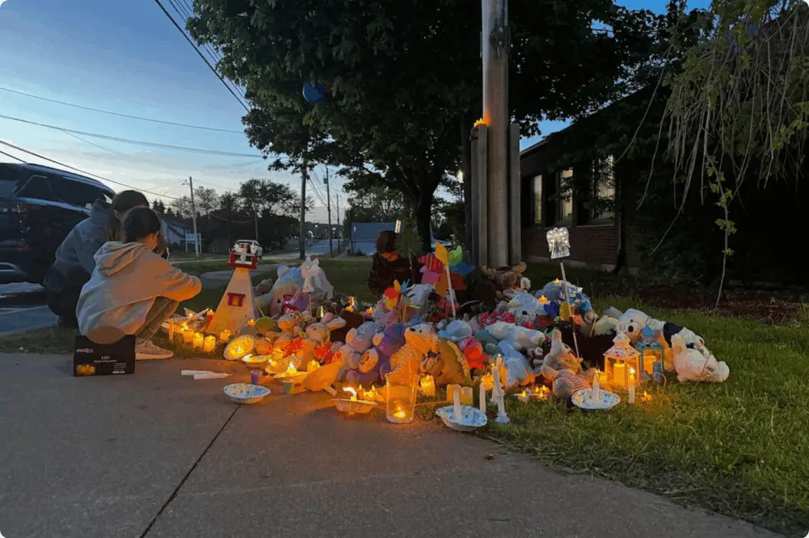About 50 community members gathered outside the RCMP detachment in Stellarton, N.S., on Monday evening for a candlelight vigil, one month after siblings Lilly and Jack Sullivan were reported missing. (Angela MacIvor/CBC - image credit)