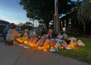 About 50 community members gathered outside the RCMP detachment in Stellarton, N.S., on Monday evening for a candlelight vigil, one month after siblings Lilly and Jack Sullivan were reported missing. (Angela MacIvor/CBC - image credit)
